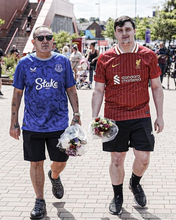 Everton fans and Liverpool fans present flowers at Anfield to commemorate Jota